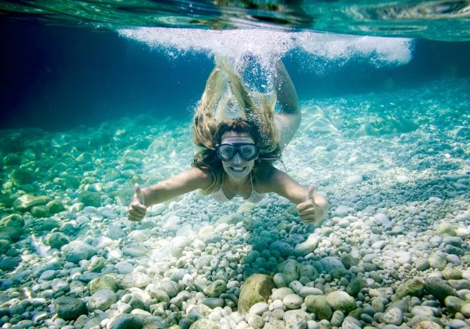 snorkeling-in-the-tropical-sea-woman-shows-thumb-u-LAF7S5D-min